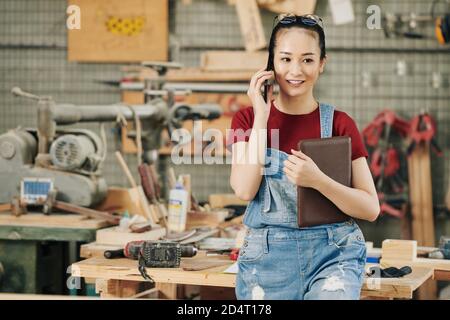 Falegname femminile che chiama al telefono Foto Stock