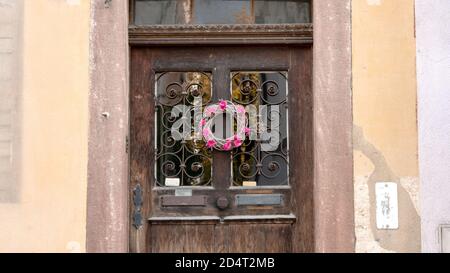 Porta vecchia con una corona di fiori Foto Stock
