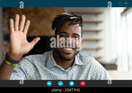 Visualizzazione dello schermo di un uomo biraciale sorridente che parla in videochiamata Foto Stock