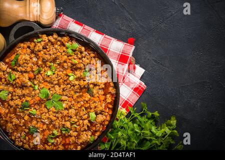 sause bolognese in piastra di ferro a tavola nera. Foto Stock