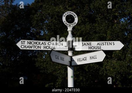 Cartello (Traffic Finger Post) al centro del villaggio Hampshire di Chawton, Inghilterra, Regno Unito Foto Stock