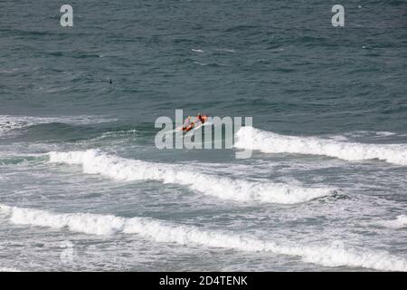Newquay, Cornovaglia, 11 ottobre 2020, la RNLI ha avuto tre barche di costola in stand-by sul mare come Surfers godere le alte onde che arrivano in Fistral Beach in Cornovaglia. La folla guardava dalla spiaggia. La gente viaggia da tutto il paese per cavalcare le famose Waves.Credit: Keith Larby/Alamy Live News Foto Stock