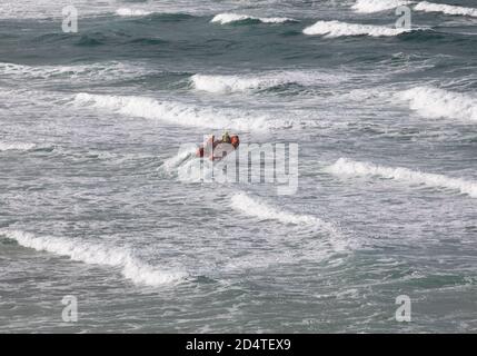 Newquay, Cornovaglia, 11 ottobre 2020, la RNLI ha avuto tre barche di costola in stand-by sul mare come Surfers godere le alte onde che arrivano in Fistral Beach in Cornovaglia. La folla guardava dalla spiaggia. La gente viaggia da tutto il paese per cavalcare le famose Waves.Credit: Keith Larby/Alamy Live News Foto Stock