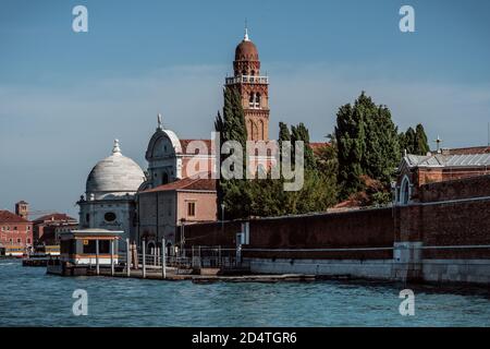 Vista laterale dell'ingresso del cimitero di San Michele a Venezia in giornata di sole Foto Stock