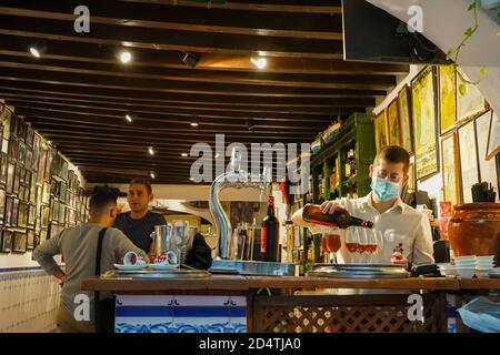 El Pimpi. Bar spagnolo tradizionale, cameriere che serve sherry, Bodegas El Pimpi, Malaga, Costa del Sol, Andalusia, Spagna. Foto Stock