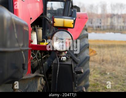 Vista ravvicinata della parte anteriore di un grande trattore rosso, del trattore per lavori in agricoltura di grandi dimensioni o di costruzione di strade e altri lavori Foto Stock