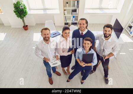 I dipendenti del reparto vendite soddisfatti che lavorano nell'ufficio aziendale che stanno cercando fotocamera Foto Stock