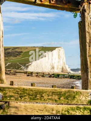 Chalk scogliera incorniciata da groyne di legno Foto Stock