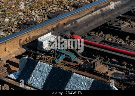 Primo piano del meccanismo di commutazione ferroviario. La traslazione della freccia. Rotaie, traversine. Foto Stock