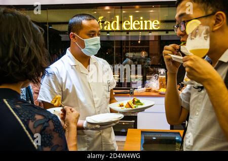 Gli ospiti che provano uova e piantano formaggio alla griglia chorizo al Future Food Studio da solo un pop up a Shanghai utilizzando un sostituto uovo a base di piante. Foto Stock