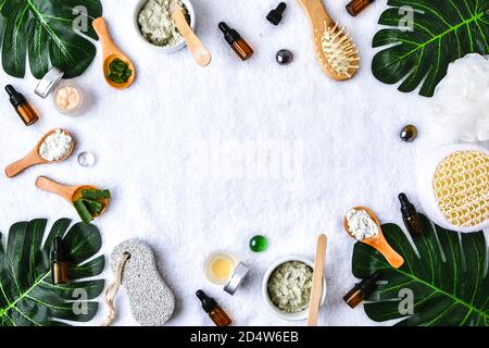 Concetto di bellezza e moda con set spa e foglie di palma. BIO erbe verde cosmetici disposizione. Spazio di copia della cornice. Foto Stock