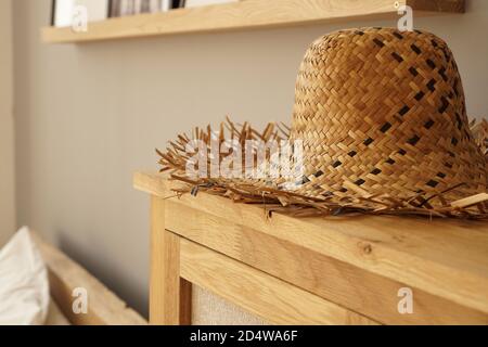 Cappello di paglia sullo scaffale in camera in stile scandinavo. Luce soffusa Foto Stock