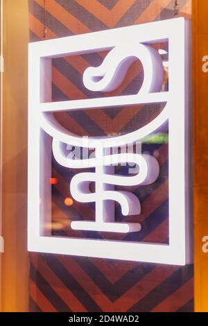 segno icona della medicina con un serpente, negozio di strada finestra di la farmacia Foto Stock