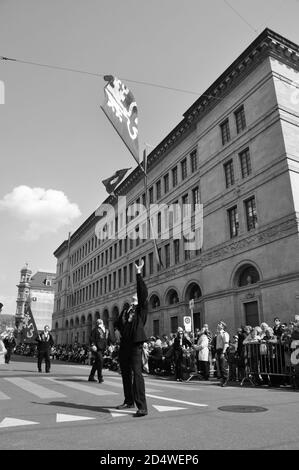 Zürich-City: bandiera svizzera prestazioni a 'Sechseläuten' sfilata di fronte alla Banca nazionale svizzera a Bahnhofstrasse Foto Stock