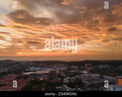 vista aerea dell'alba sulla città con nuvole tempestose Foto Stock