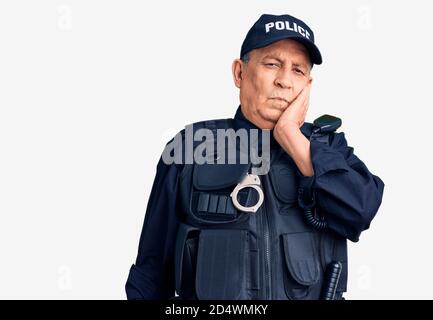 Uomo anziano bello che indossa la polizia uniforme pensare stanco e annoiato con problemi di depressione con le braccia incrociate. Foto Stock