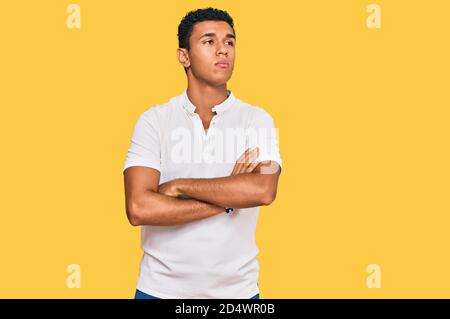 Giovane arabo che indossa abiti casual guardando al lato con armi incrociate convinte e fiduciose Foto Stock