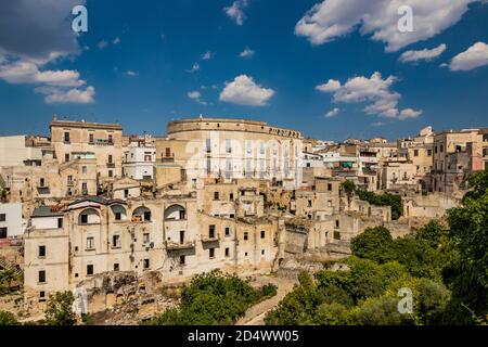 Gravina in Puglia, Italia. Lo skyline della città con le sue antiche case ed edifici. Alcuni muri rotti e resti di case crollate e rovinate. Foto Stock