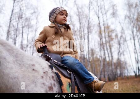 Cute piccola ragazza seduta su Pony Foto Stock