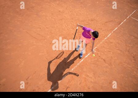 Il giovane tennista si prepara a servire la palla Foto Stock