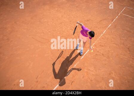 Il giovane tennista si prepara a servire la palla Foto Stock