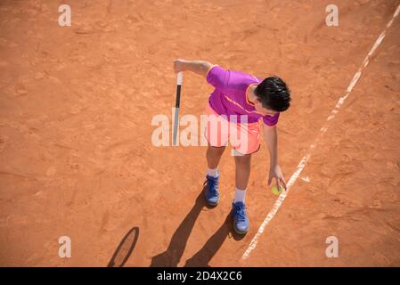 Il giovane tennista si prepara a servire la palla Foto Stock