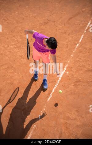 Il giovane tennista si prepara a servire la palla Foto Stock