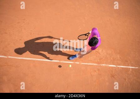 Il giovane tennista si prepara a servire la palla Foto Stock