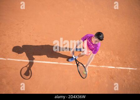 Il giovane tennista si prepara a servire la palla Foto Stock