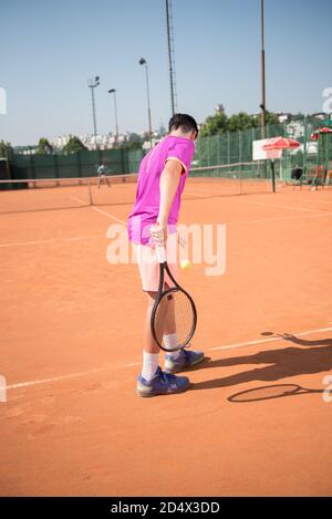 Il giovane tennista si prepara a servire la palla Foto Stock