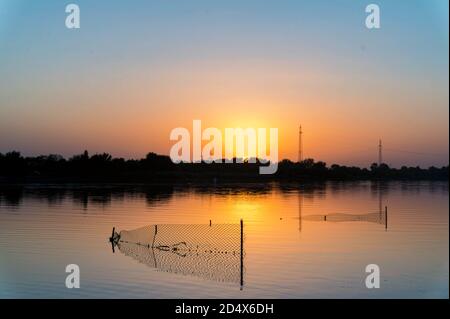 Stazionaria lift rete di pesca trappola al fiume al tramonto Foto Stock