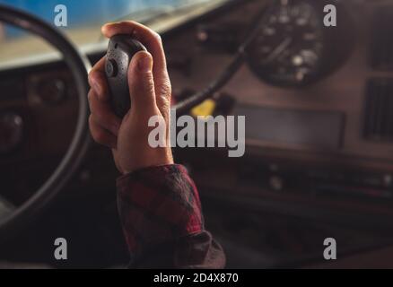 Il Trucker caucasico comunica con altri conducenti di veicoli in convoglio tramite il concetto di primo piano della radio CB. Tema industria dei trasporti. Foto Stock