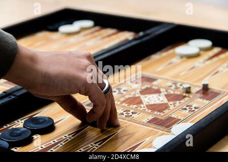 Mano di donna che muove le pedine in un gioco di backgammon Foto Stock