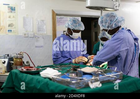 Makeni, Sierra Leone - 22 giugno 2019: Medici chirurghi che operano su un paziente in un ospedale africano, strumenti su un tavolo Foto Stock