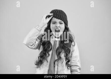 urlando la bambina di sfondo rosa. giacca piumino e cappello a maglia. shopping invernale. come vestirsi caldo in inverno. Il mio abbigliamento Preferito. Pronto per l'inverno freddo. Clima freddo. Foto Stock