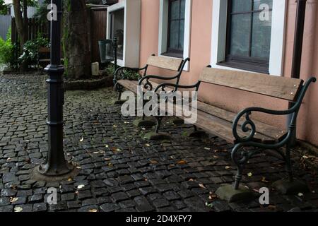 Cortile in acciottolato di stile europeo con panchine antiche Foto Stock