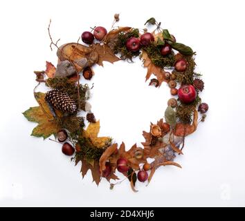 corona autunnale di foglie gialle di mele e castagne uno sfondo bianco Foto Stock