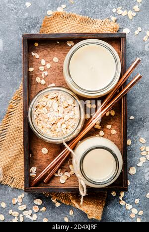 Latte in scaglie di avena vegana, latte alternativo non caseario in vetro, vista dall'alto, spazio copia Foto Stock