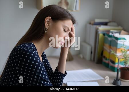 Infelice donna stanca che soffre di sovraccarico di lavoro giorno. Foto Stock