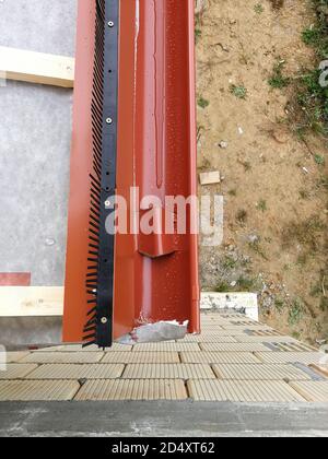 Grondaia con tubo discendente per la raccolta di acqua piovana in casa in costruzione in cantiere Foto Stock