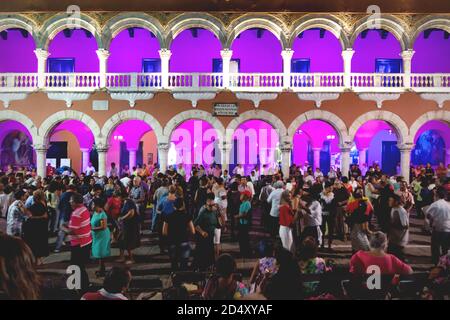 Merida, Messico - Ottobre 28 2018: Folla danzante di persone di fronte all'illuminato edificio coloniale 'Palacio Municipal' di notte Foto Stock