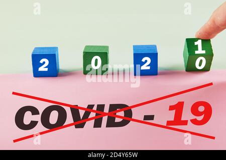La mano trasforma il cubo e cambia l'anno 2020 da Covid-19 a 2021 senza coronavirus. Foto Stock