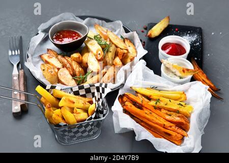 Diversi tipi di patate fritte . Spicchi di patate, patatine fritte, patate dolci. Foto Stock