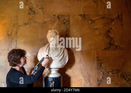 Un membro del personale del National Trust's Mottisfont in Hampshire, pulisce un busto di marmo nella Long Gallery, mentre preparano l'ex convento medievale prima di riaprire la casa ai membri del pubblico il lunedì, dopo il blocco del coronavirus. Foto Stock