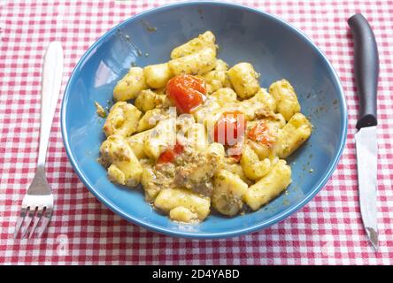 gnocchi con pesto al basilico e pomodori pachino Foto Stock