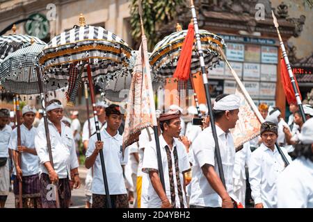 Galungan Vacanze. Festa processione di giovani con ombrelli in mano. Isola di Bali, Indonesia.26.12.2018. Foto Stock