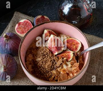 una salutare ciotola di cereali con mandorle arrostite, cannella e fichi serviti in una ciotola senza latte Foto Stock