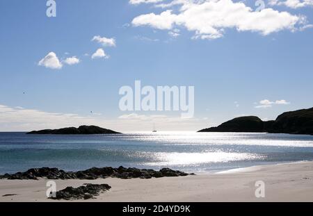 Yacht passando Scoor Beach, una spiaggia di sabbia appartata, sulla Ross of Mull, Isola di Mull, Scozia Regno Unito Foto Stock