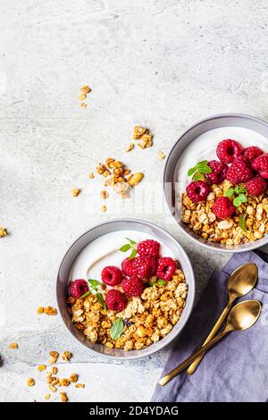 Muesli con lamponi e yogurt in una ciotola grigia. Concetto di cibo sano. Foto Stock