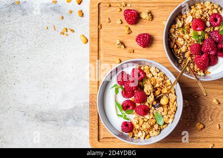 Muesli con lamponi e yogurt in una ciotola grigia. Concetto di cibo sano. Foto Stock